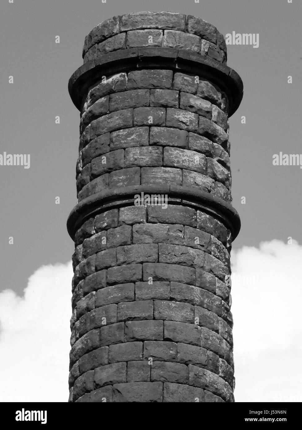 Vecchio mulino in pietra Camino con Cielo e nubi Foto Stock