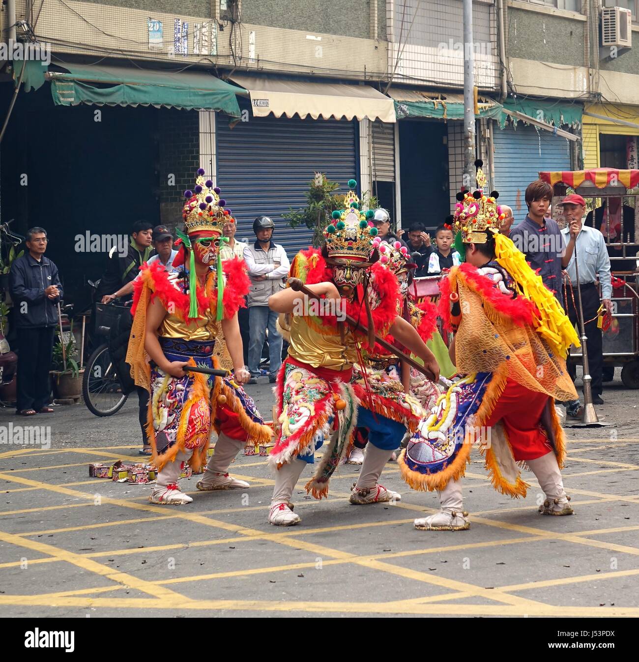 KAOHSIUNG, Taiwan -- Marzo 16, 2014: tre giovani uomini con dipinti di maschere per il viso e il vestito come antichi guerrieri danza in un tempio locale cerimonia. Foto Stock