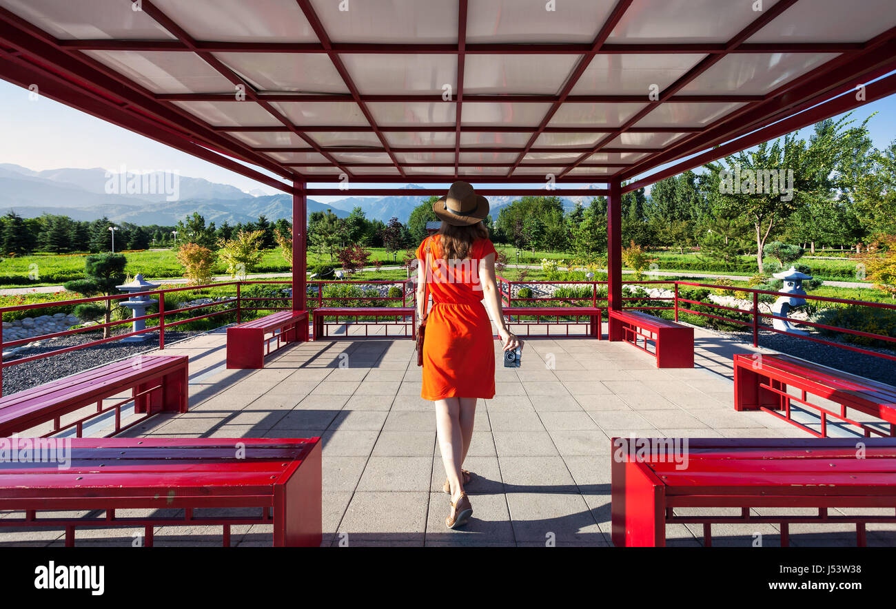 Donna in abito arancione con fotocamera foto andando alla Pagoda giapponese Foto Stock