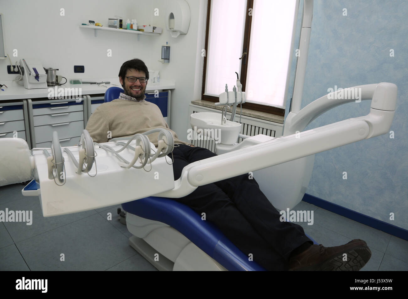 Adulto Uomo seduto in poltrona del dentista in chirurgia dentale Foto Stock