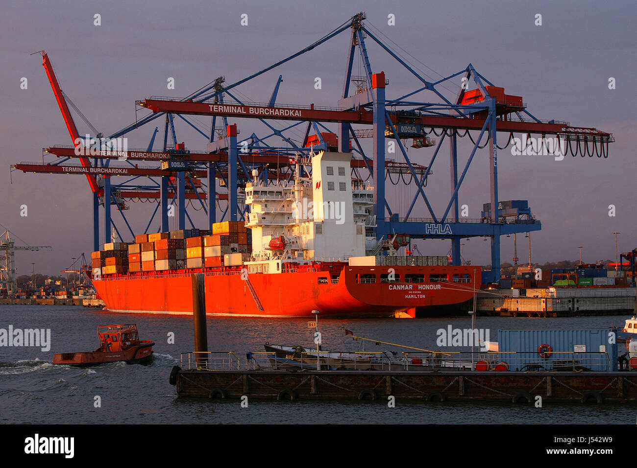 Contenitore di carico della nave mercantile rimorchiatore nave carica arancione contenitore di scarico Foto Stock