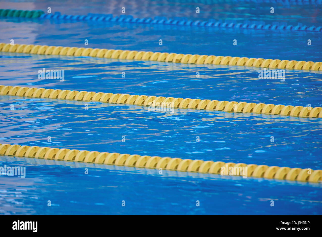 Corsie giallo in blu acqua di piscina di close-up. Ancora acqua di piscina Foto Stock