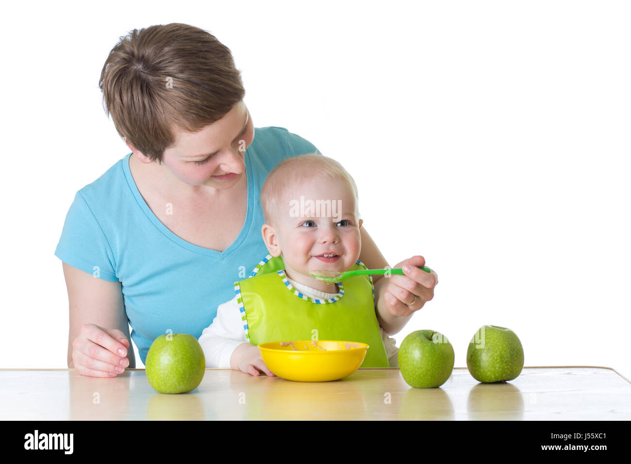 Cucchiaio di madre-alimentando il suo bambino isolato su bianco Foto Stock