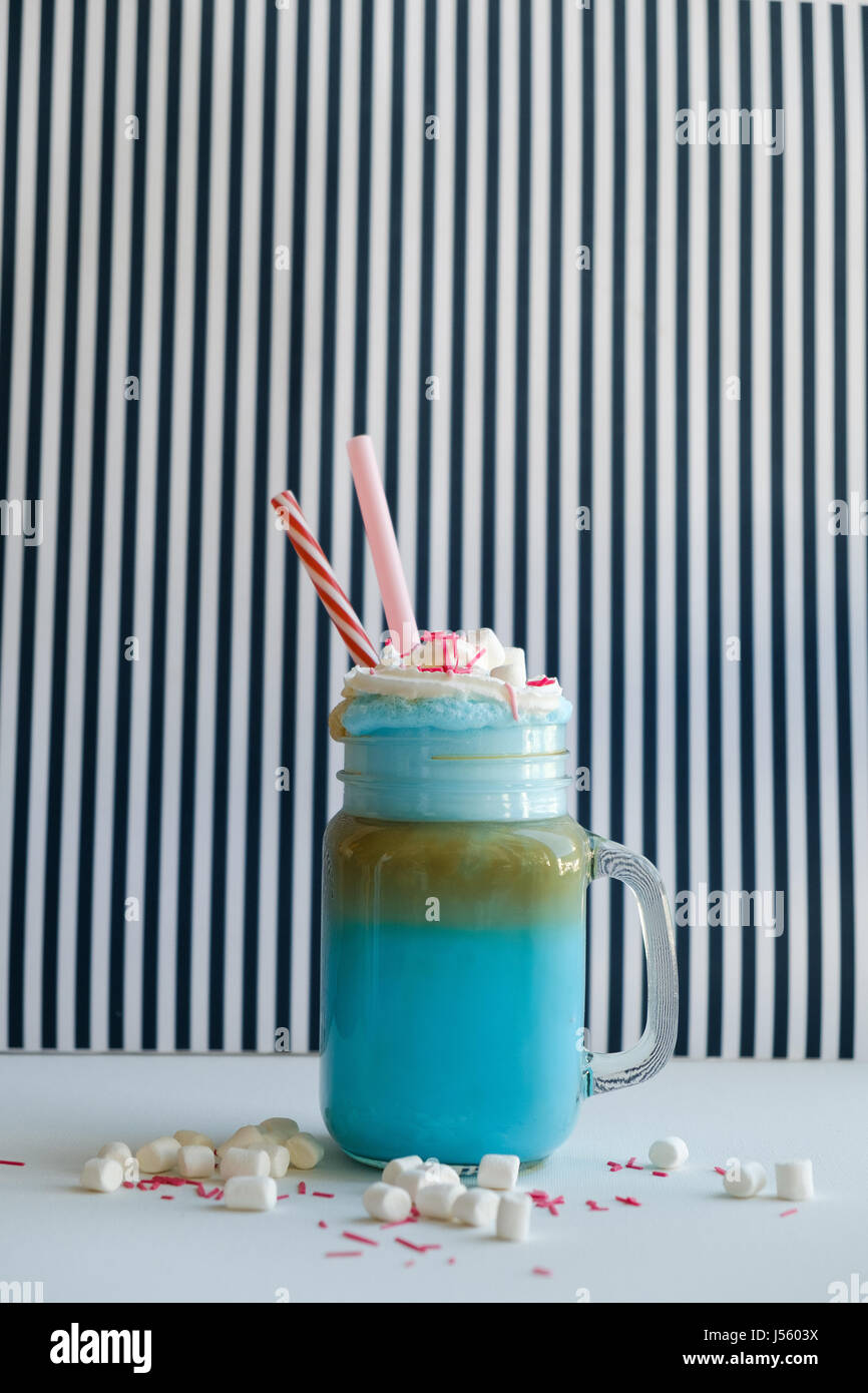Blue caffè con panna, marshmallow e decorazione colorata su una in bianco e nero dello sfondo. Milk Shake. Unicorn caffè. Unicorn cibo Foto Stock
