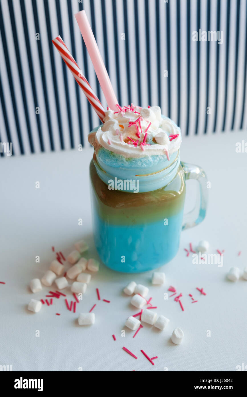 Blue caffè con panna, marshmallow e decorazione colorata su una in bianco e nero dello sfondo. Milk Shake. Unicorn caffè. Unicorn cibo Foto Stock