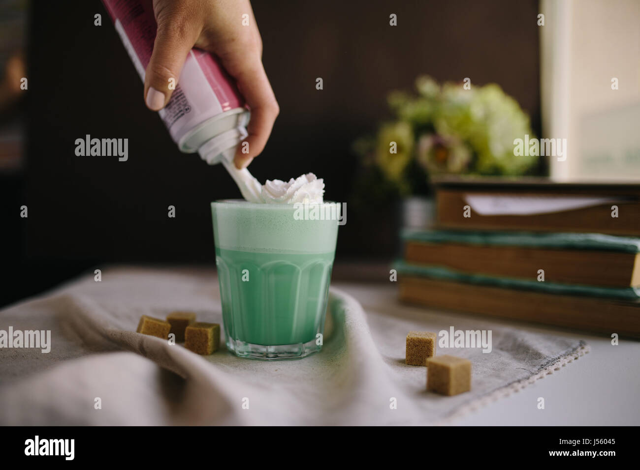 Ragazza è decorare la crema in tazza di verde menta caffè. Milk Shake, cocktaill, il Frappuccino. Unicorn caffè, unicorn cibo. Foto Stock