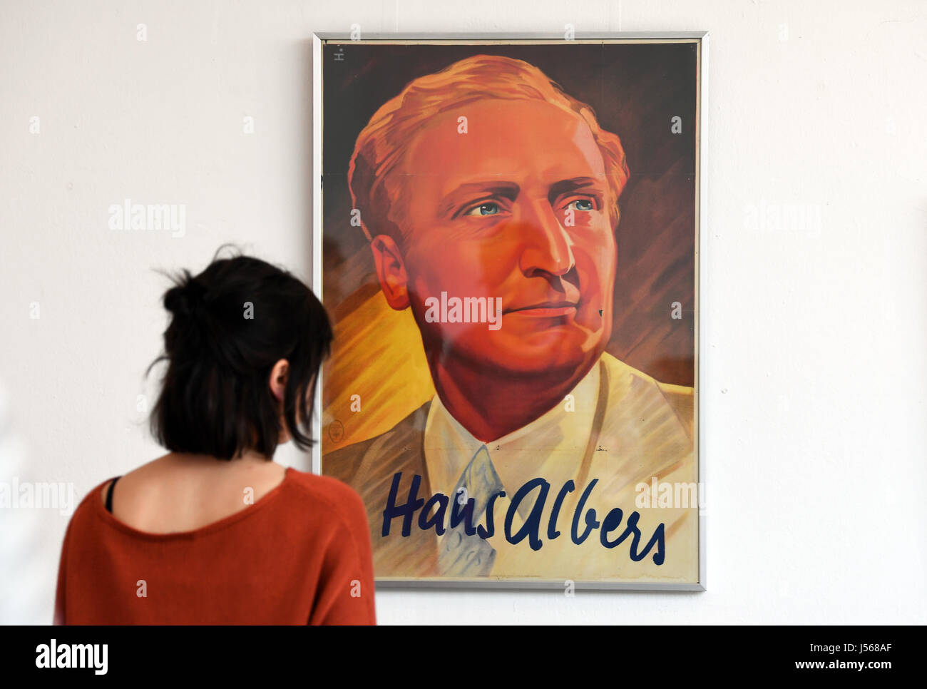 Una donna prende uno sguardo a un poster storico mostra attore Hans Albers a Potsdam il film museum, Germania, 16 maggio 2017. Hans Alber (1891 - 1960) salire alla stella di UFA (Universum Film AG) industria cinematografica negli anni trenta del novecento è argomento di una mostra nel foyer di Potsdam il museo dei film con il nome "Hans Albers - das Mannbild der Ufa' (lit. "Hans Albers - lui-uomo di UFA'). Foto: Ralf Hirschberger/dpa-Zentralbild/dpa Foto Stock