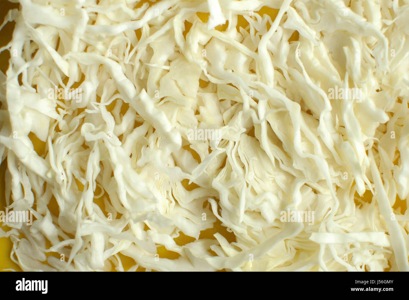 Fette di cavolo bianco su sfondo giallo tagliere vicino. Messa a fuoco selettiva. Foto Stock