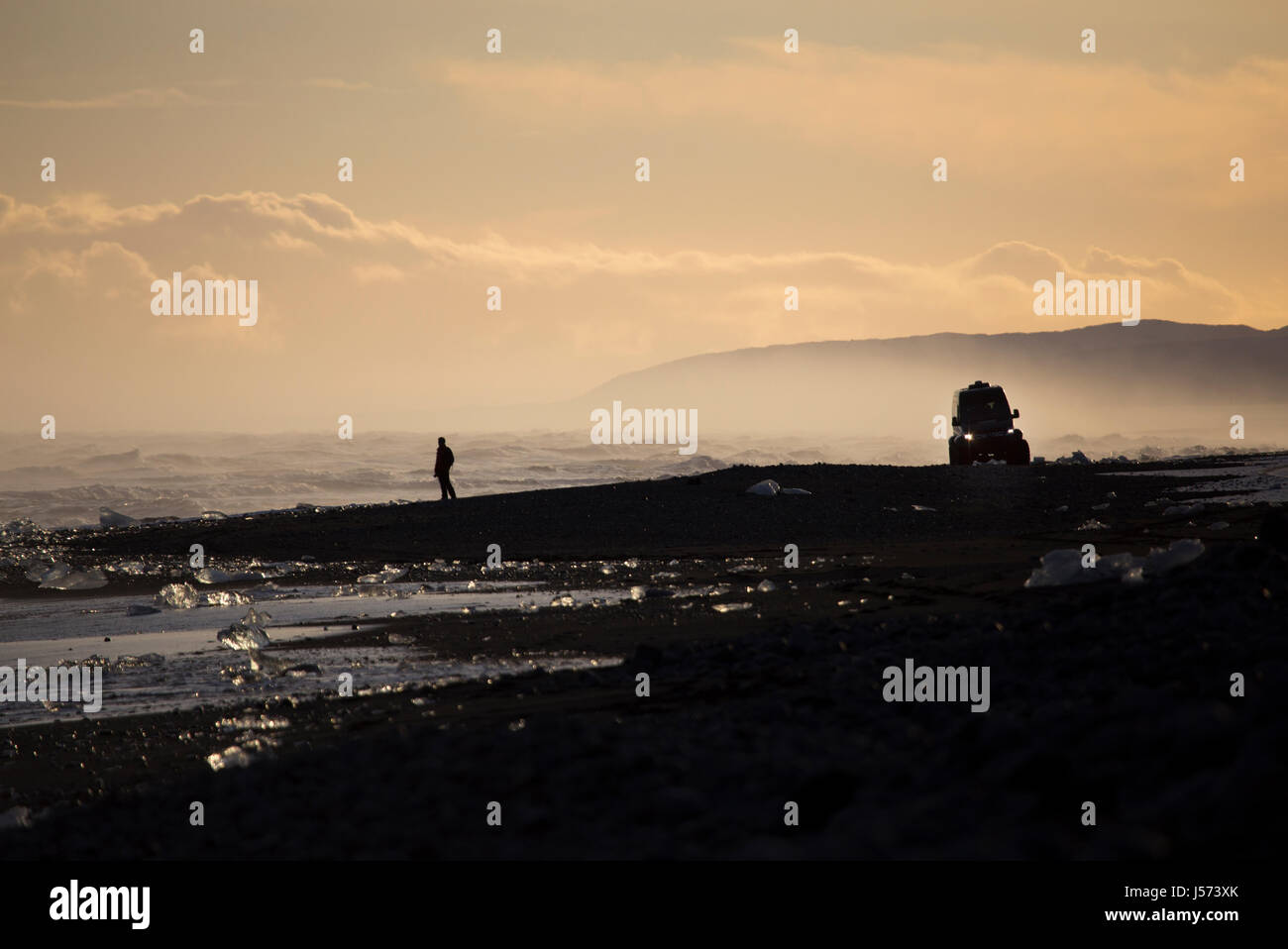 Una persona godendo la vista sulla spiaggia di Diamante vicino alla laguna glaciale nel sud est dell'Islanda Foto Stock