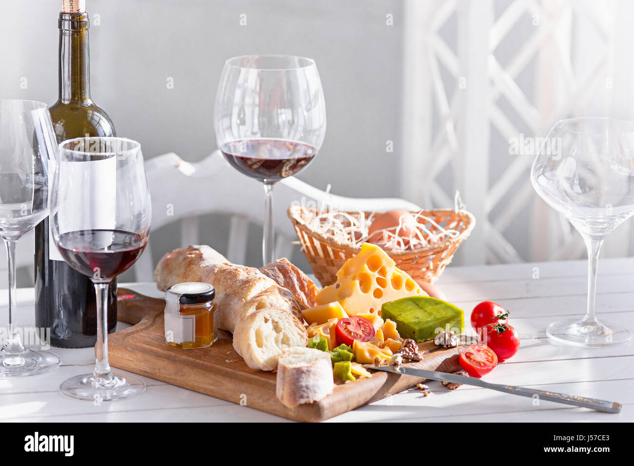 Vino, baguette e formaggio su sfondo di legno Foto Stock