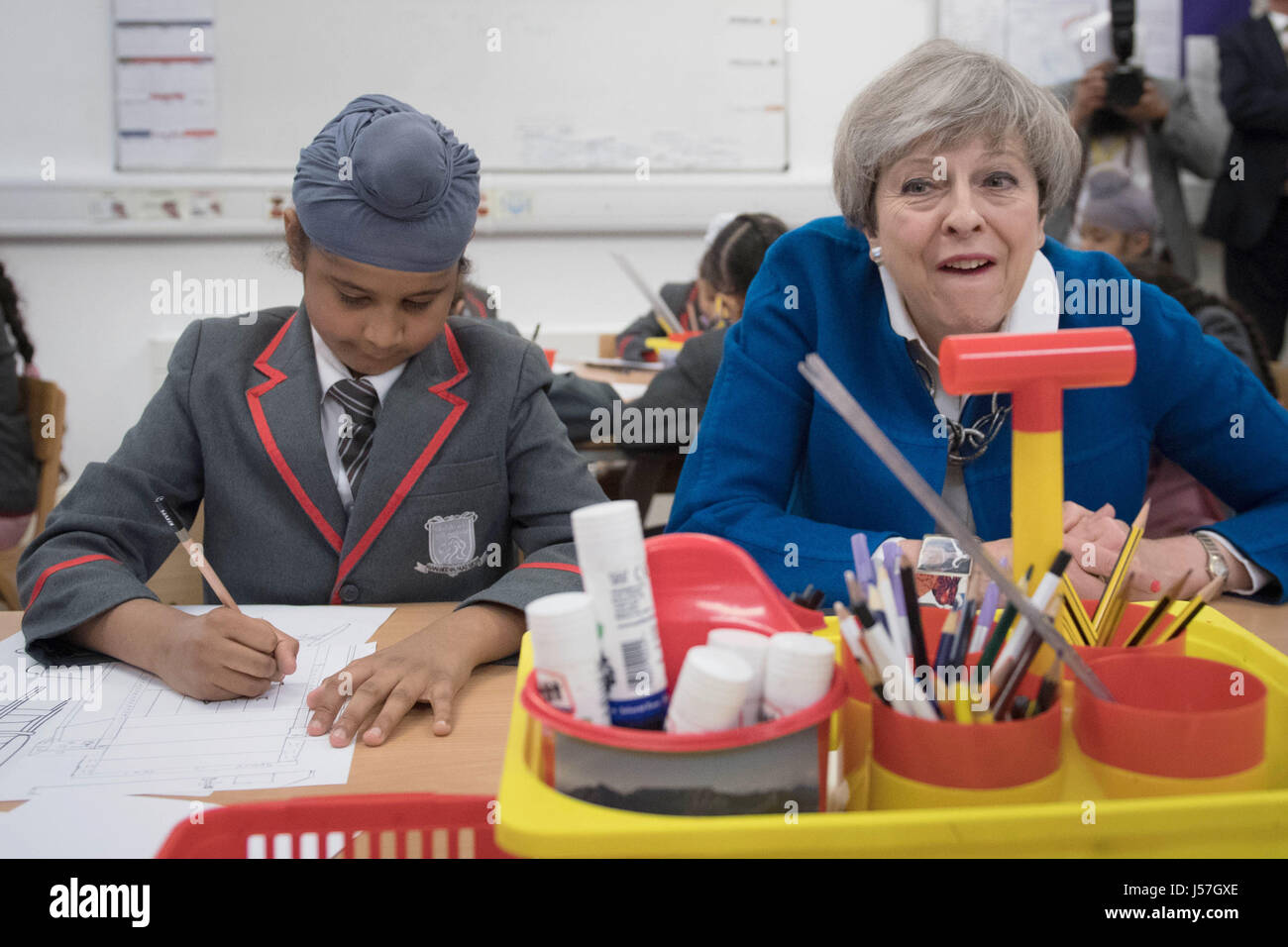Partito conservatore leader Theresa Maggio con otto anni di Akaal Singh come incontra gli alunni a Nishkam scuola primaria a Birmingham, durante una campagna elettorale visita al West Midlands. Foto Stock