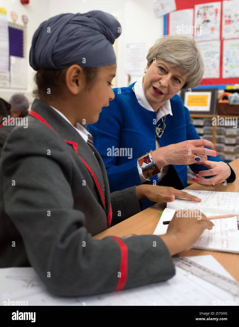 Partito conservatore leader Theresa Maggio con otto anni di Akaal Singh come incontra gli alunni a Nishkam scuola primaria a Birmingham, durante una campagna elettorale visita al West Midlands. Foto Stock