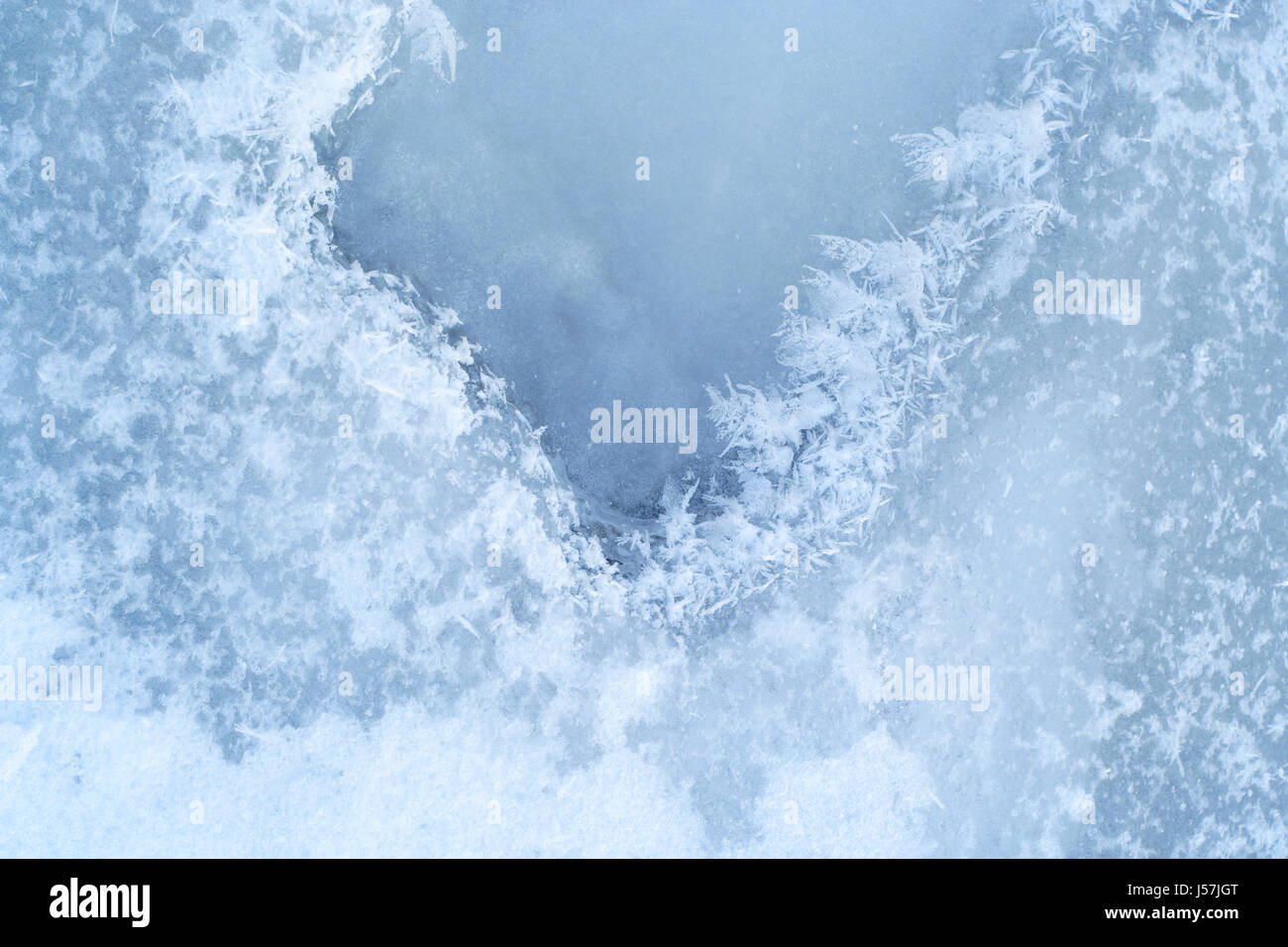 Close-up di ghiaccio-acqua legata alla superficie con pattern di cristalli all'inverno. Foto Stock