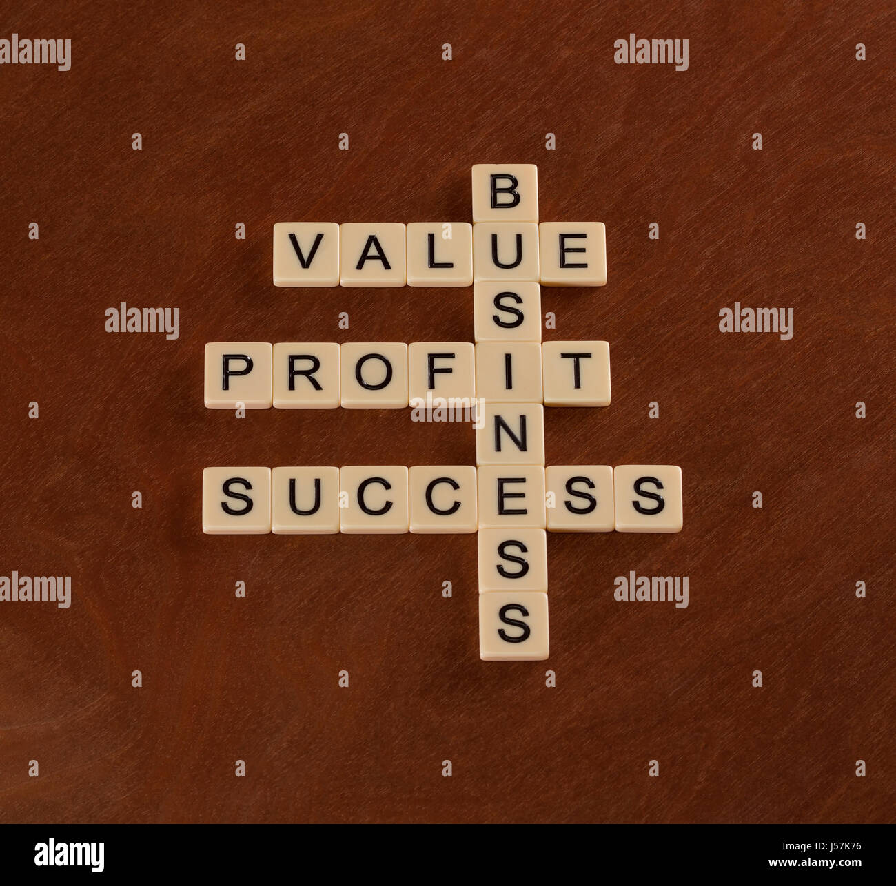 Cruciverba con parole valore, profitti aziendali. Successo nel Business del concetto. Piastrelle color avorio con lettere maiuscole sulla scheda di mogano. Foto Stock