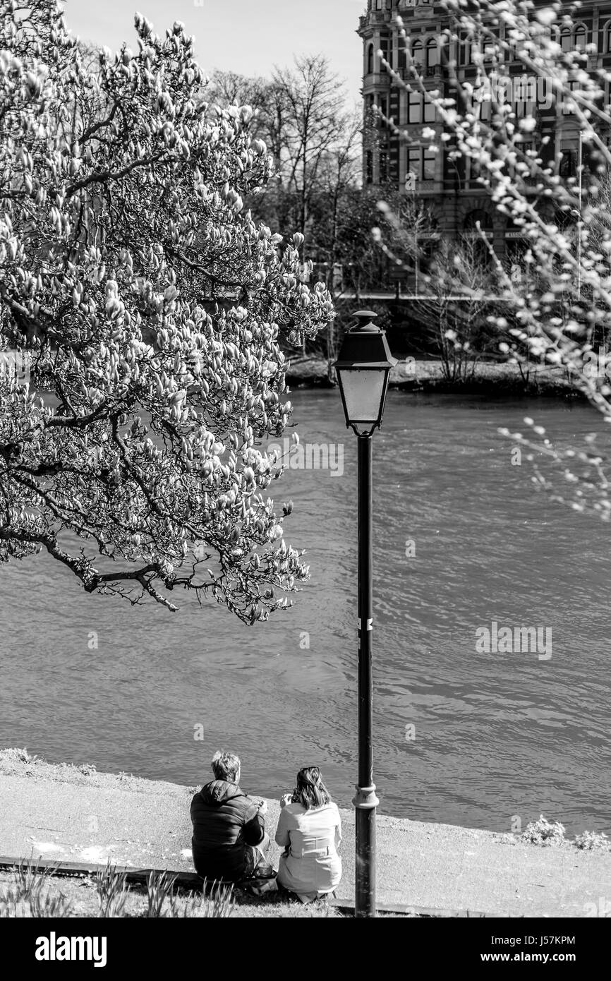 Coppia seduta vicino al fiume, giornata di primavera Foto Stock