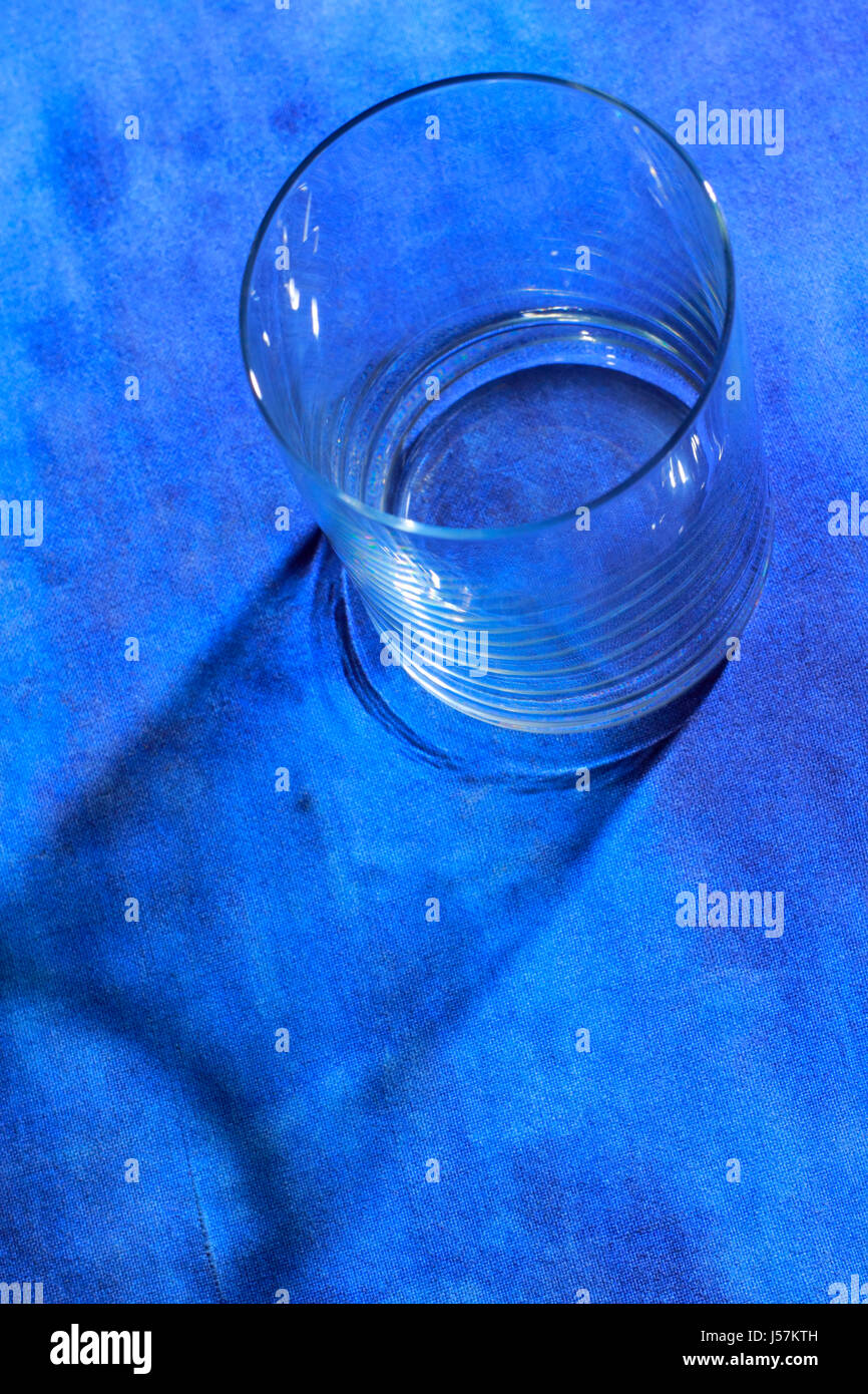 Bicchiere vuoto dal di sopra nel blu dipinto di sfondo tessili Foto Stock