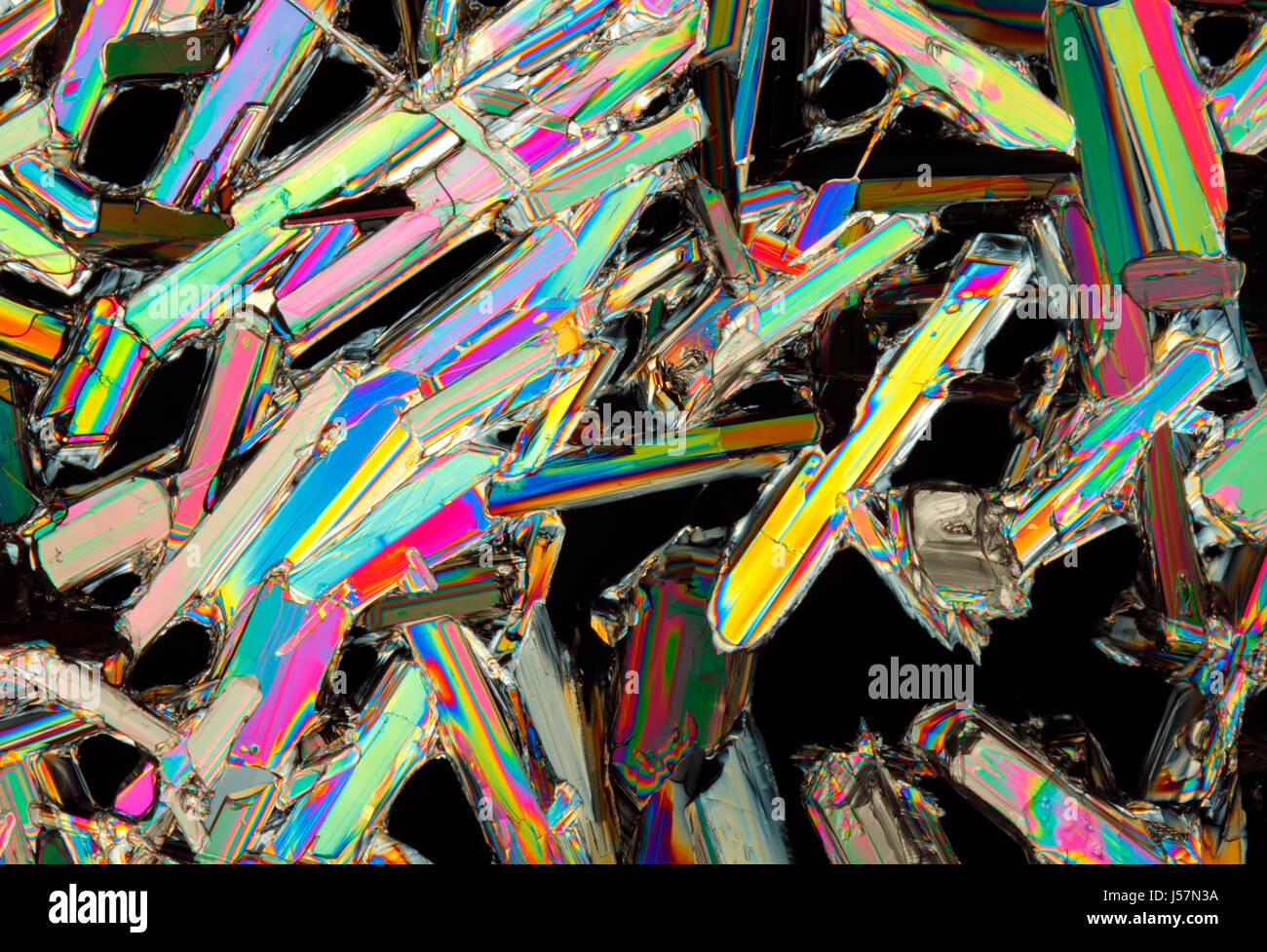 Vista microscopico di colorati di nitrato di potassio cristalli. Luce polarizzata, polarizzatori incrociati. Foto Stock