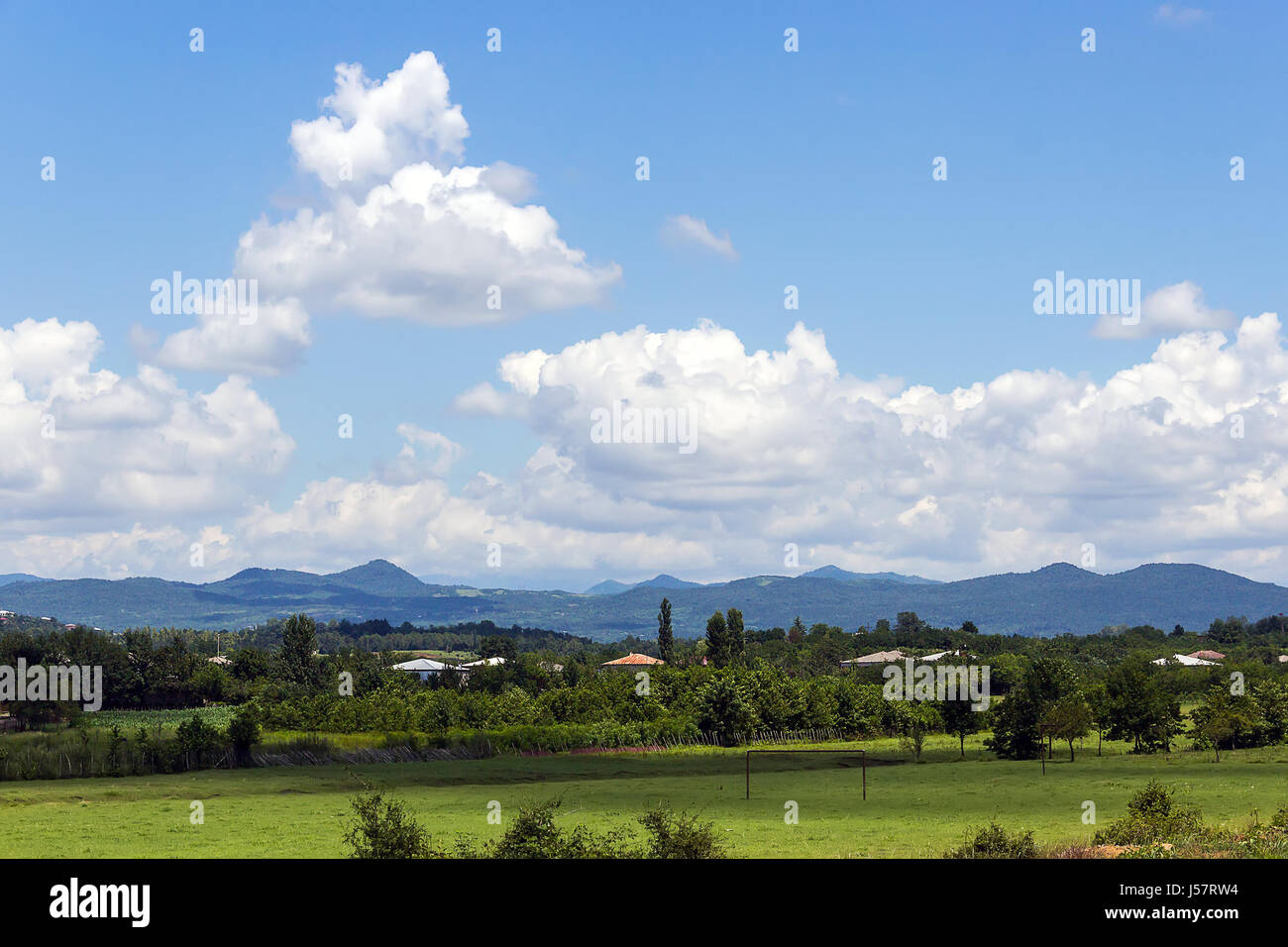 Bella nuvole sopra la fertile valle di fronte alla cresta su una soleggiata giornata estiva, alle pendici del crinale caucasico, Kuhi, Georgia Foto Stock