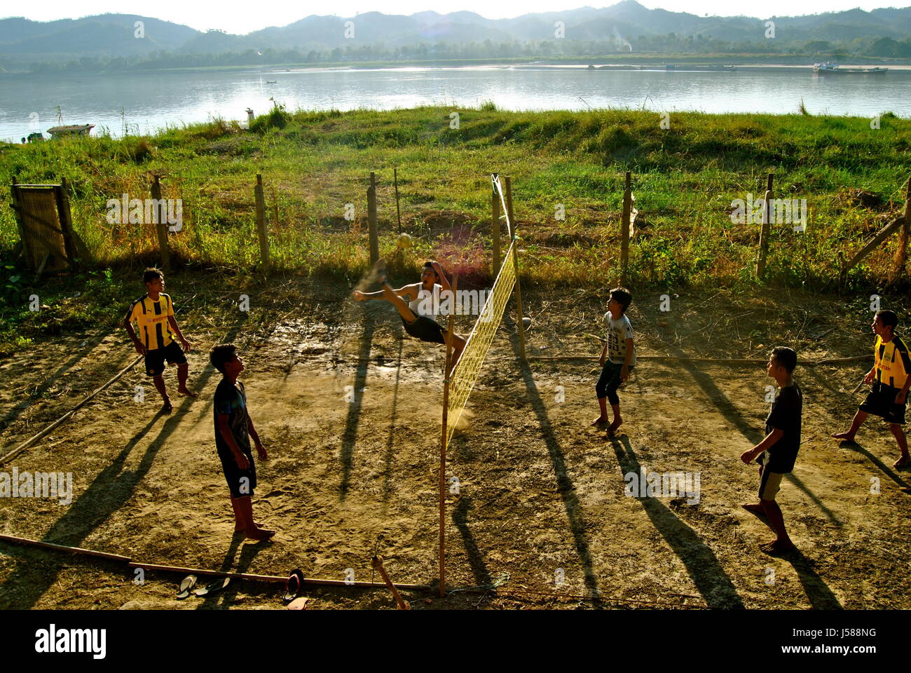 Giovani uomini giocando sepak takraw vicino al fiume Irrawaddy, Pyay, Myanmar Foto Stock