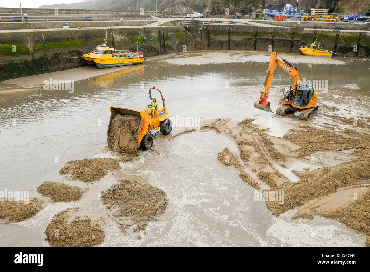 Saundersfoot Harbour manutenzione. Impianto di pesanti macchinari per aiutare a mantenere il canale chiaro. Pembrokeshire, West Wales. Regno Unito. Foto Stock