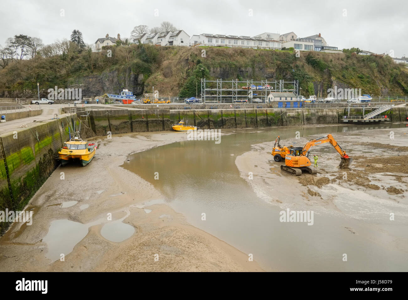 Saundersfoot Harbour manutenzione. Impianto di pesanti macchinari per aiutare a mantenere il canale chiaro. Pembrokeshire, West Wales. Regno Unito. Foto Stock
