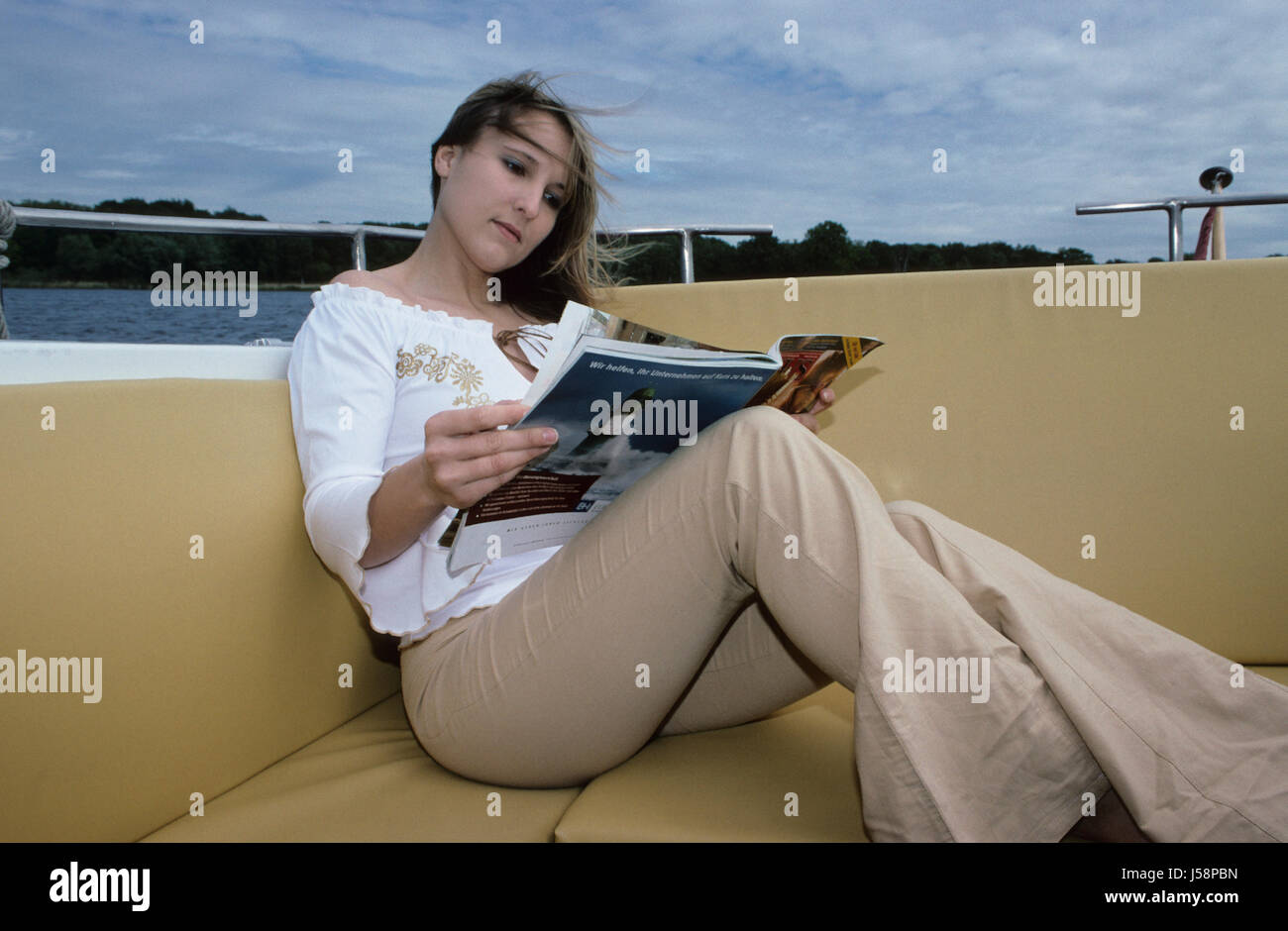 Giovane donna lettura in barca Foto Stock