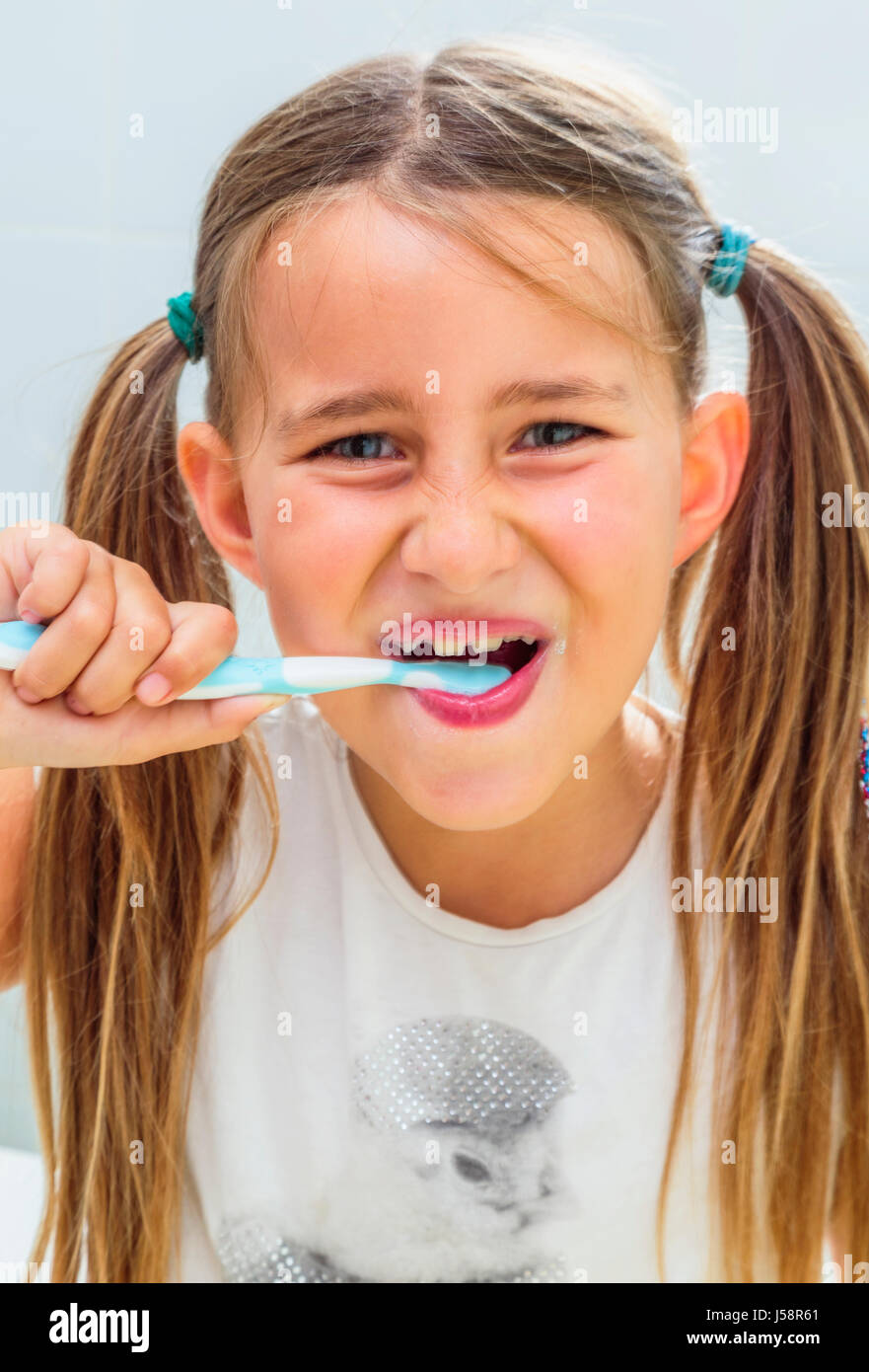 7 anno vecchia ragazza la pulizia dei denti. Foto Stock