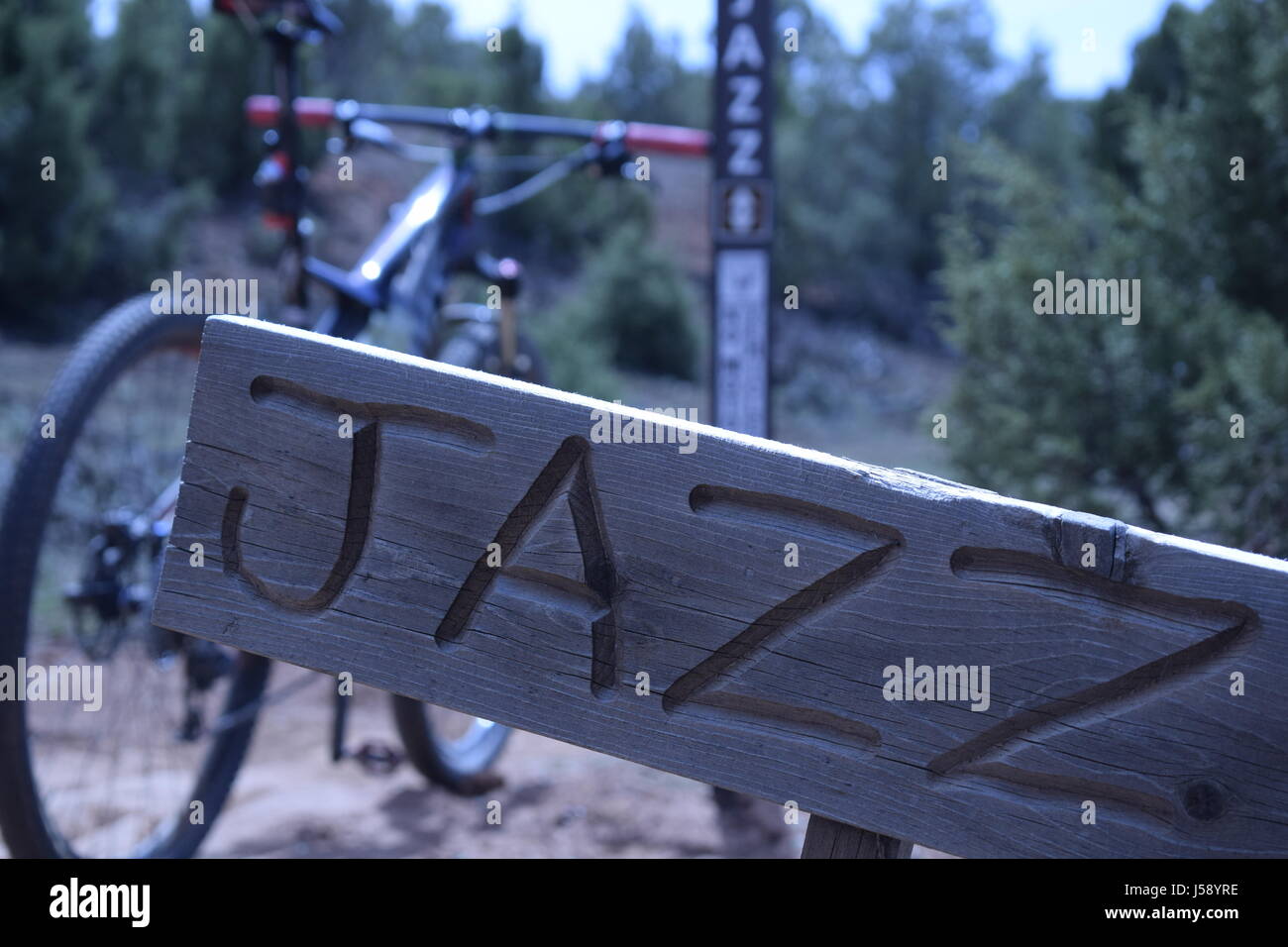 Segno che indica l'inizio del sentiero Jazz-Chromoly con una mountain bike in background, prese a flotta rosso, vicino primaverile, Utah. Foto Stock