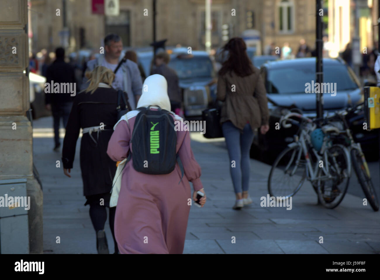 Famiglia asiatica rifugiato vestito Hijab sciarpa su strada nel Regno Unito scena quotidiana Foto Stock