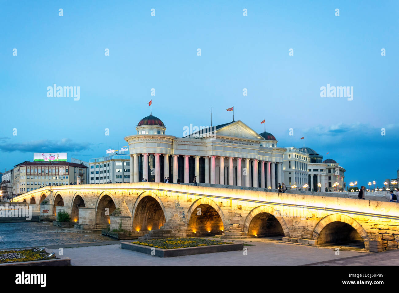 Il vecchio ponte di pietra e il Museo di Archeologia di fronte fiume Vardar al crepuscolo, Skopje, Regione di Skopje, Repubblica di Macedonia del nord Foto Stock