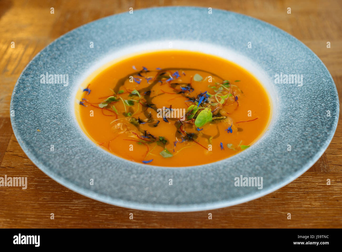 Arancione zuppa di zucca con erbe aromatiche. Cucina vegana Foto Stock