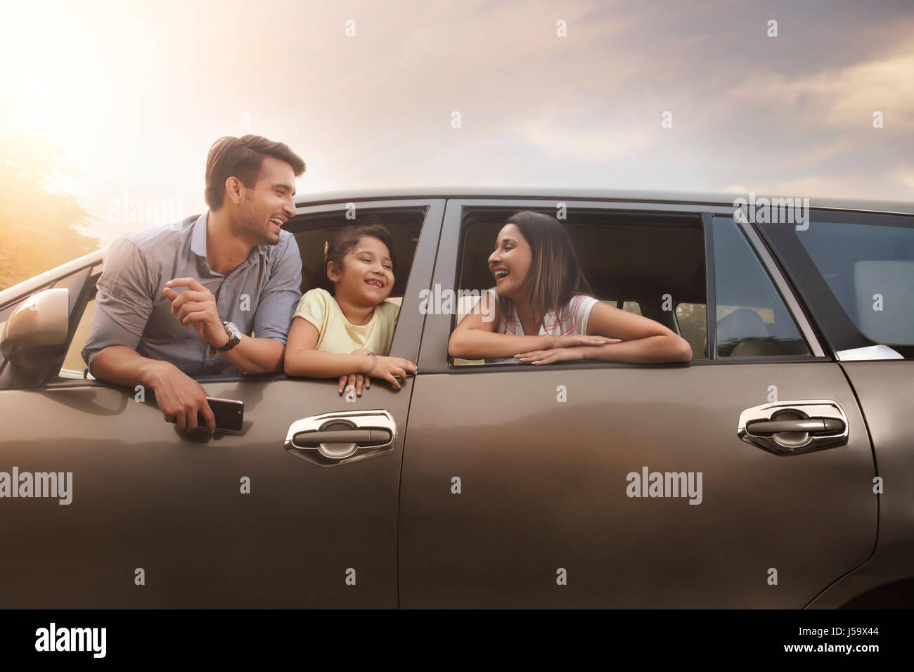 Famiglia a guardare fuori dalla finestra auto durante il loro viaggio su strada Foto Stock