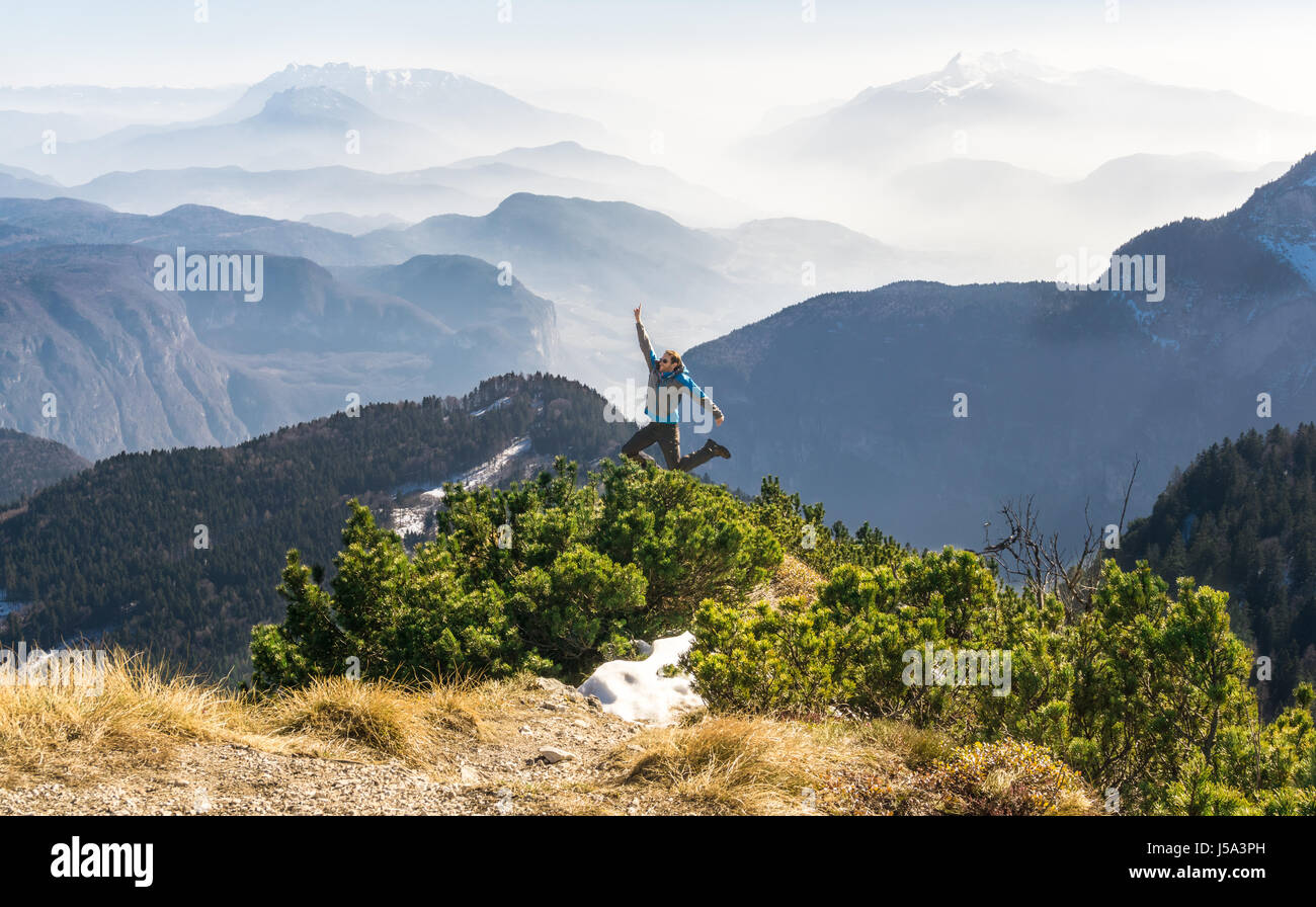 Felice successo uomo vincente sul vertice di montagna salti di gioia Foto Stock
