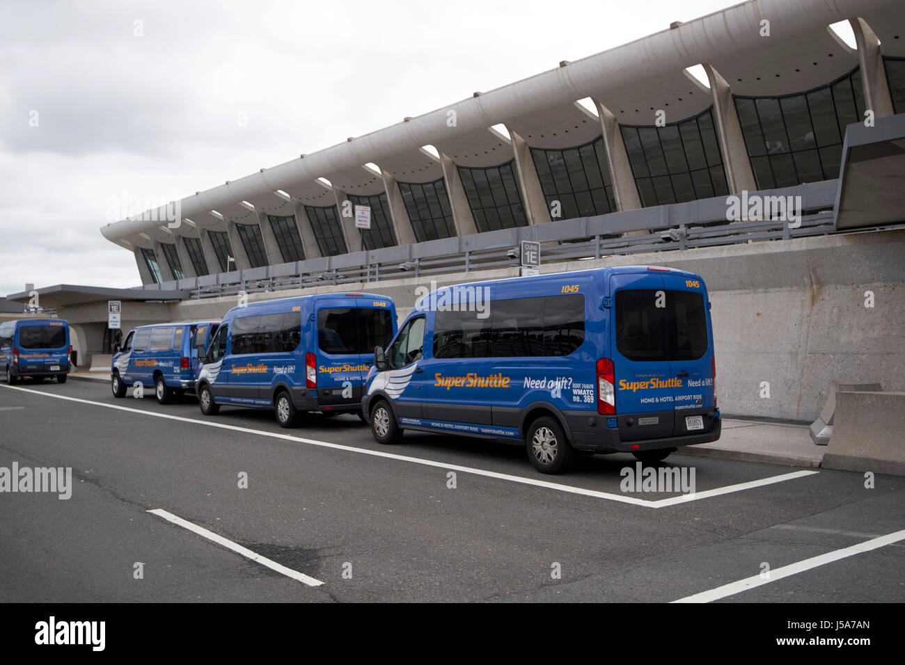 Supershuttle Shared Ride Vans parcheggiato all'esterno degli Arrivi Aeroporto Internazionale Dulles che serve a Washington DC USA Foto Stock