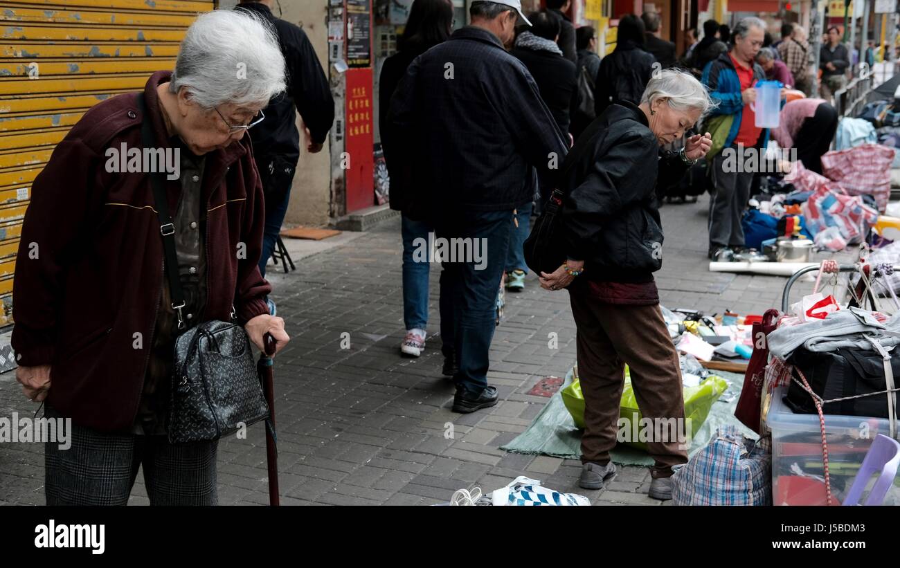 La gente anziana acquistando e vendendo i loro averi Yen Chow St Mercato delle Pulci a Sham Shui Po Kowloon Hong Kong Foto Stock