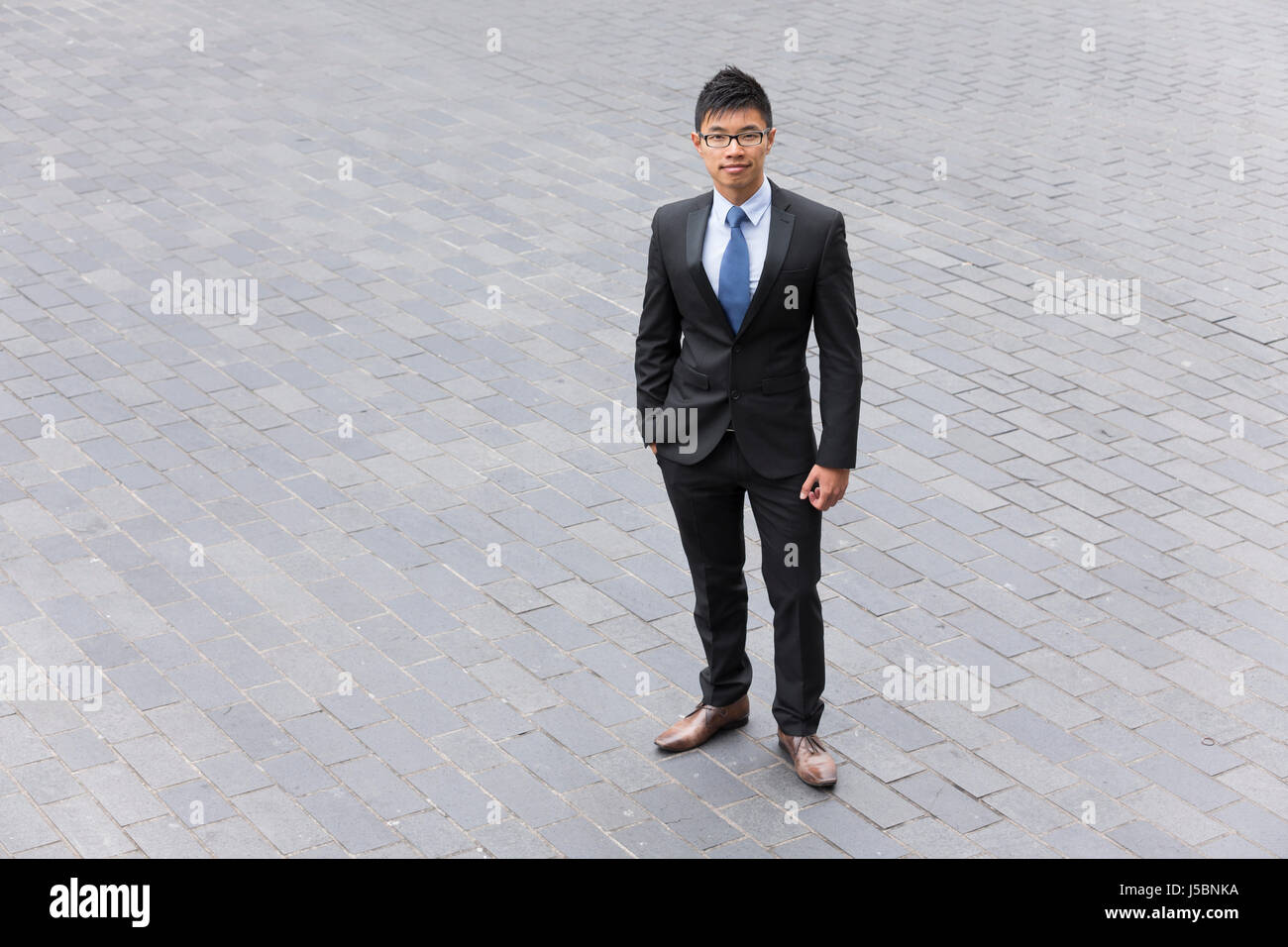 Elevato angolo di visione di un imprenditore cinese in piedi in strada. Foto Stock