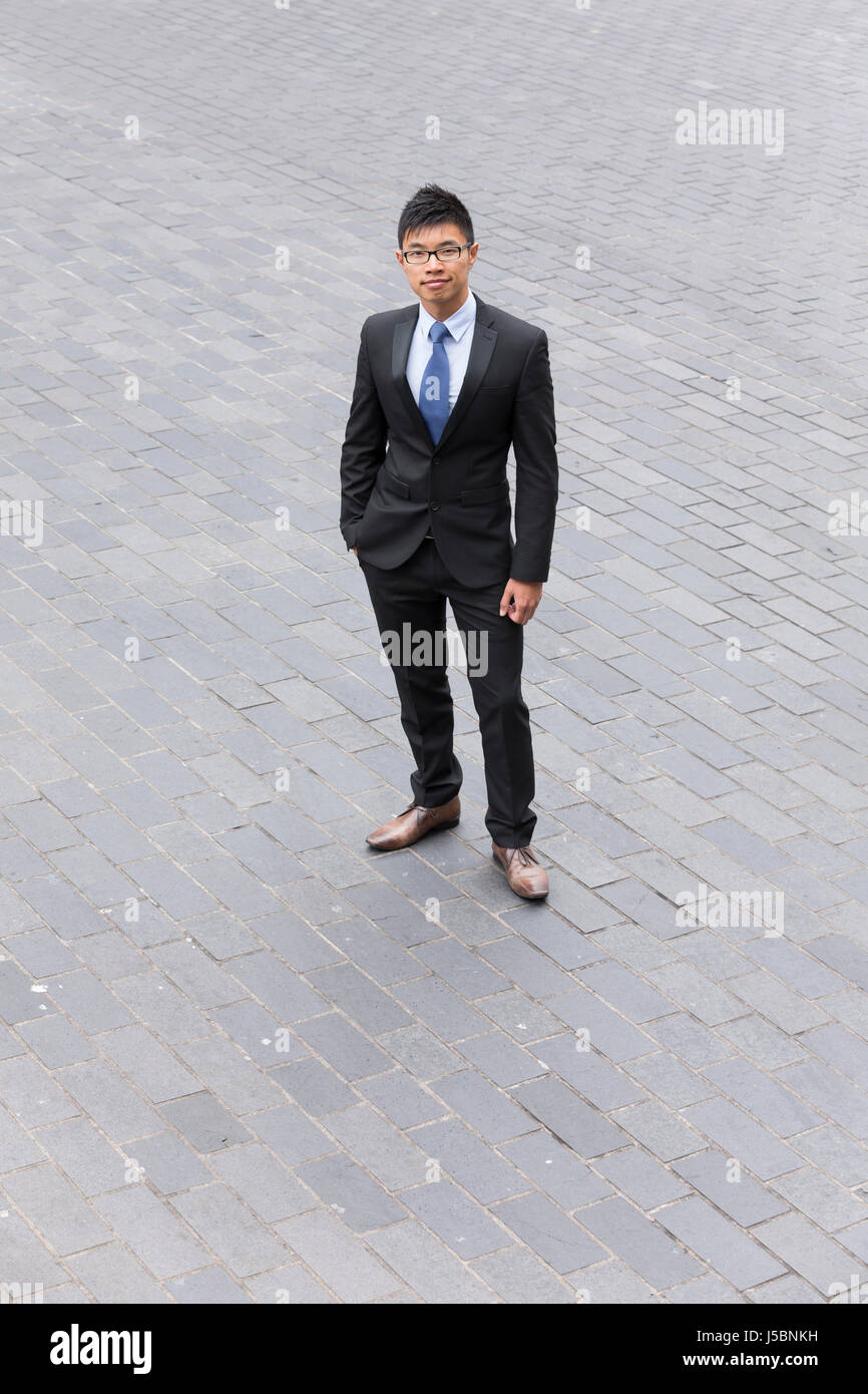 Elevato angolo di visione di un imprenditore cinese in piedi in strada. Foto Stock