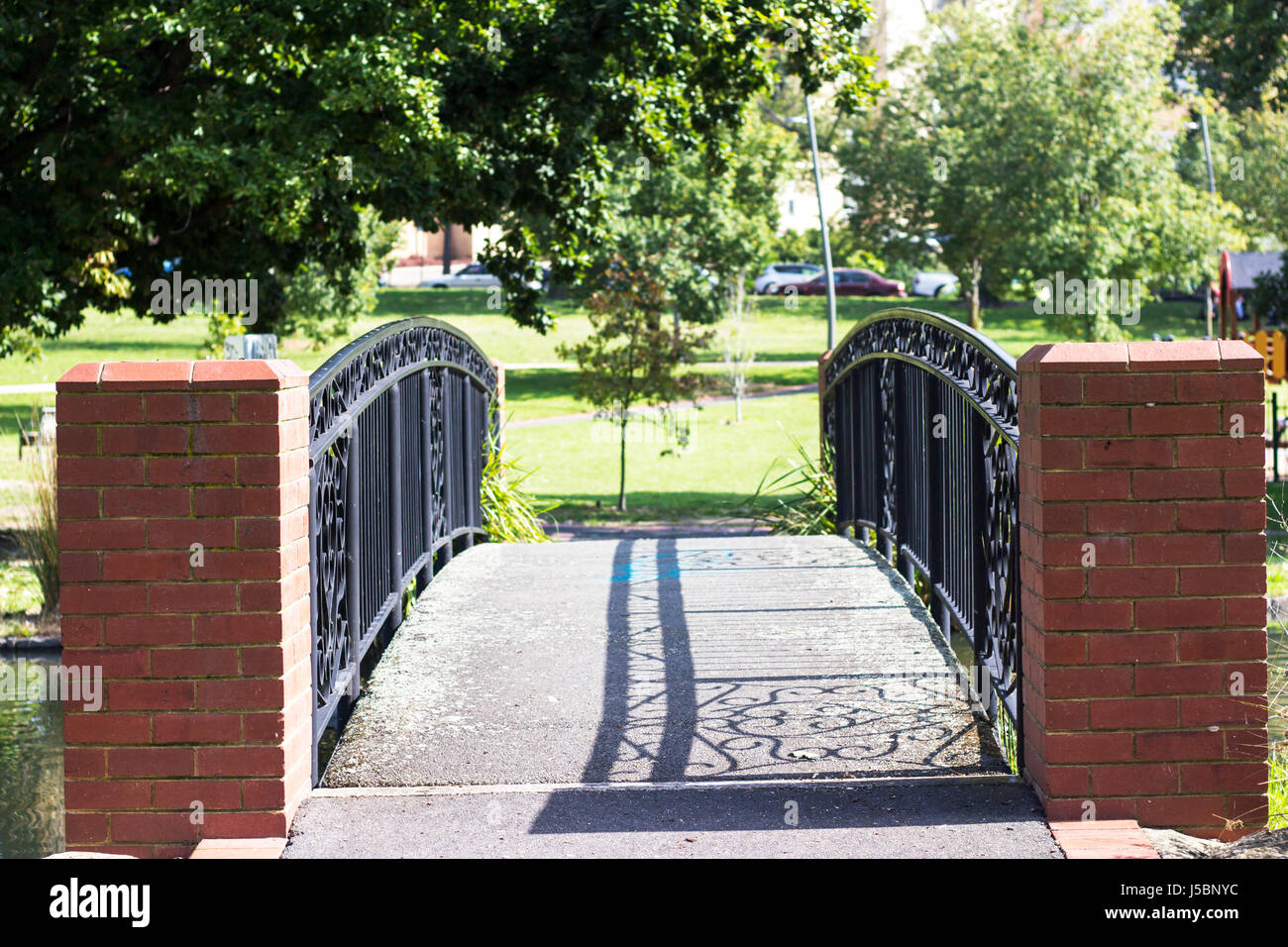 Ombre sul ponte sopra il lago locale al Box Hill Gardens Foto Stock