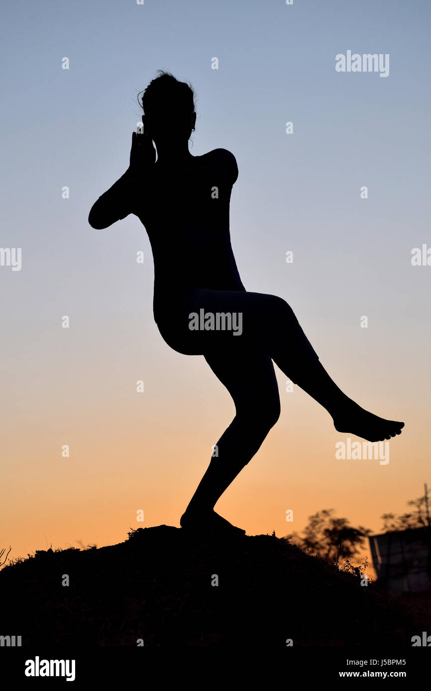 Silhouette della bambina nella danza classica pongono nei pressi di montagna, Pune, Maharashtra Foto Stock