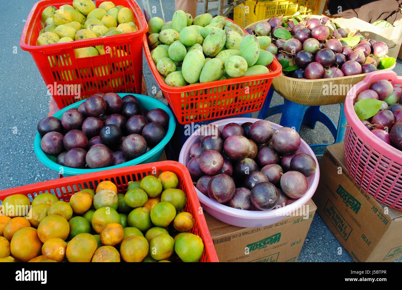 Una varietà di fresca frutta tropicale frutti tropicali esposti per la vendita sulle banchine sono una visione comune nel sud-est asiatico. Foto Stock