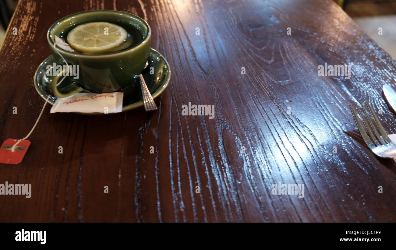 Tazza di tè caldo con limone e zucchero su una tavola è servita in un ristorante caffetteria Foto Stock