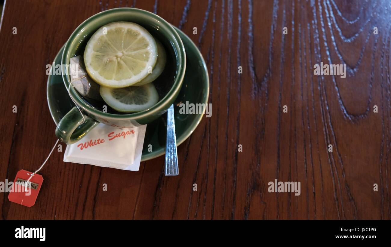 Tazza di tè caldo con limone e zucchero su una tavola è servita in un ristorante caffetteria Foto Stock