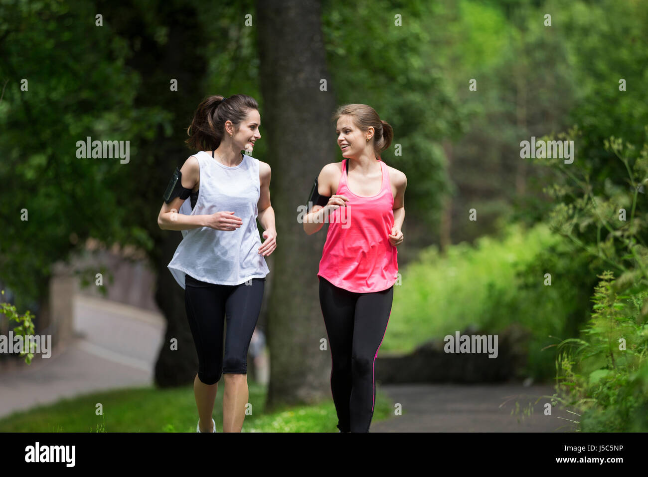 Due donna atletica in esecuzione all'esterno. Azione e uno stile di vita sano concetto. Foto Stock