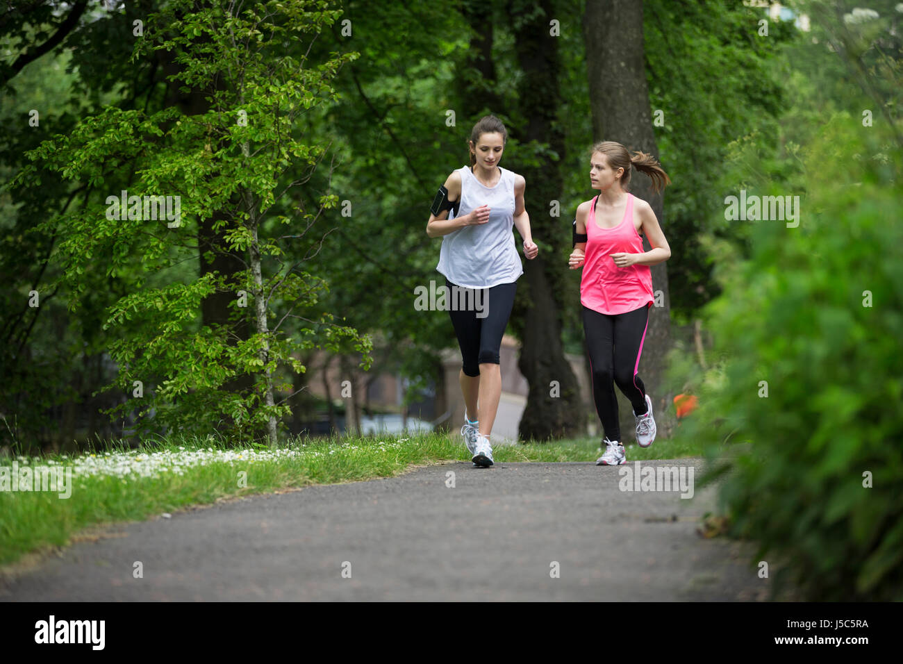 Due donna atletica in esecuzione all'esterno. Azione e uno stile di vita sano concetto. Foto Stock