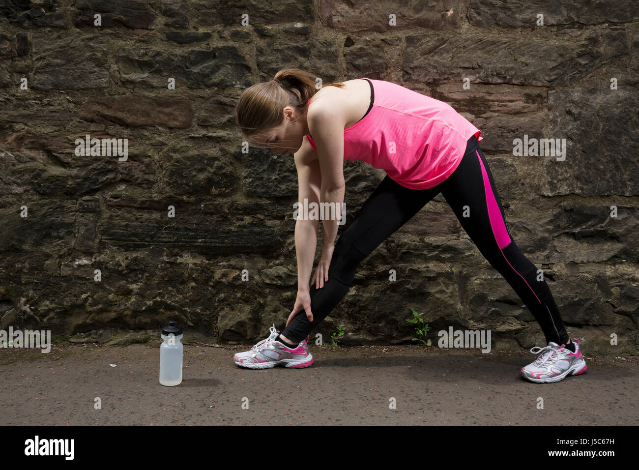 Athletic donna stretching prima o dopo la formazione. Azione e uno stile di vita sano concetto. Foto Stock