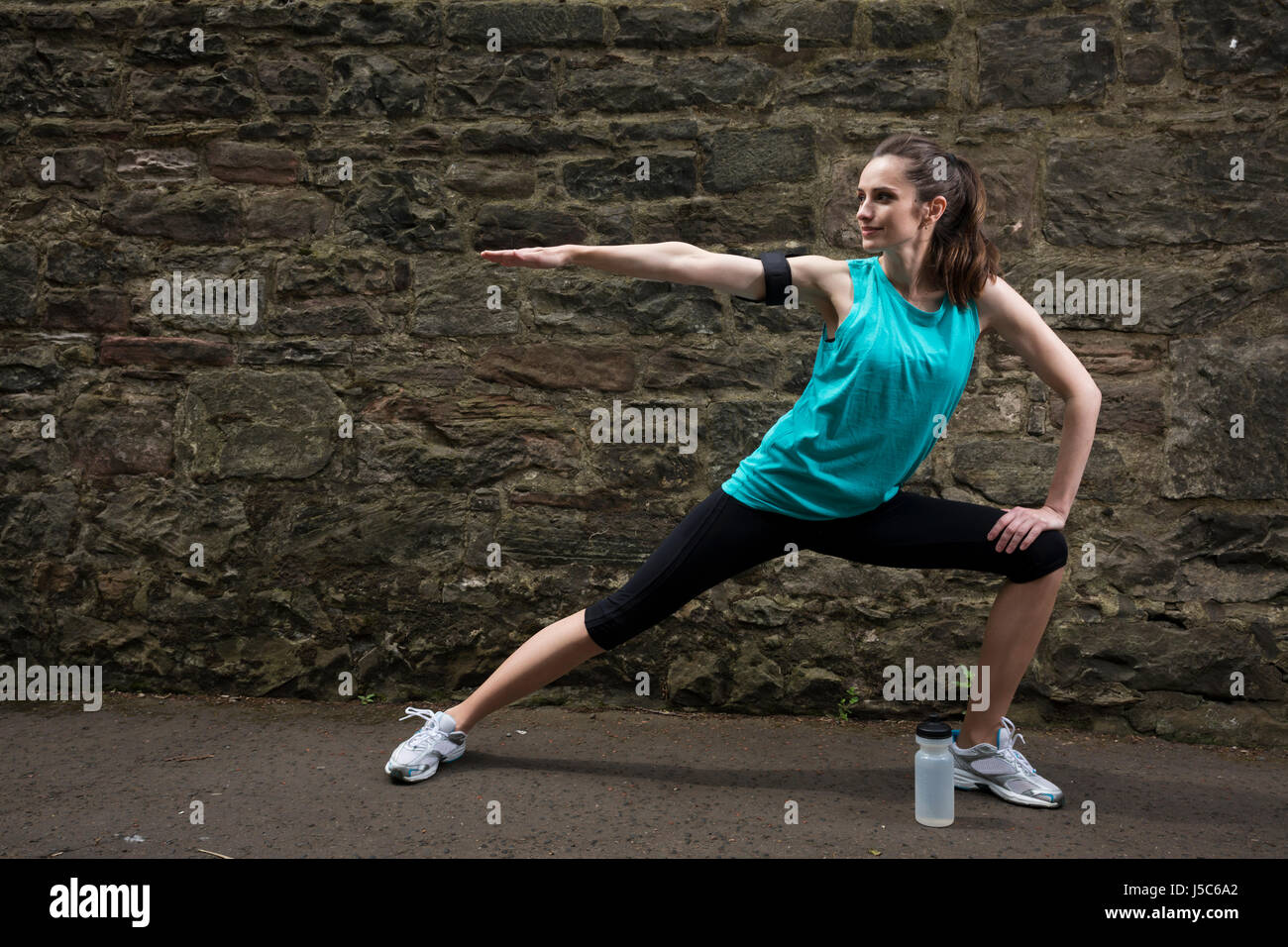Athletic donna stretching prima o dopo la formazione. Azione e uno stile di vita sano concetto. Foto Stock
