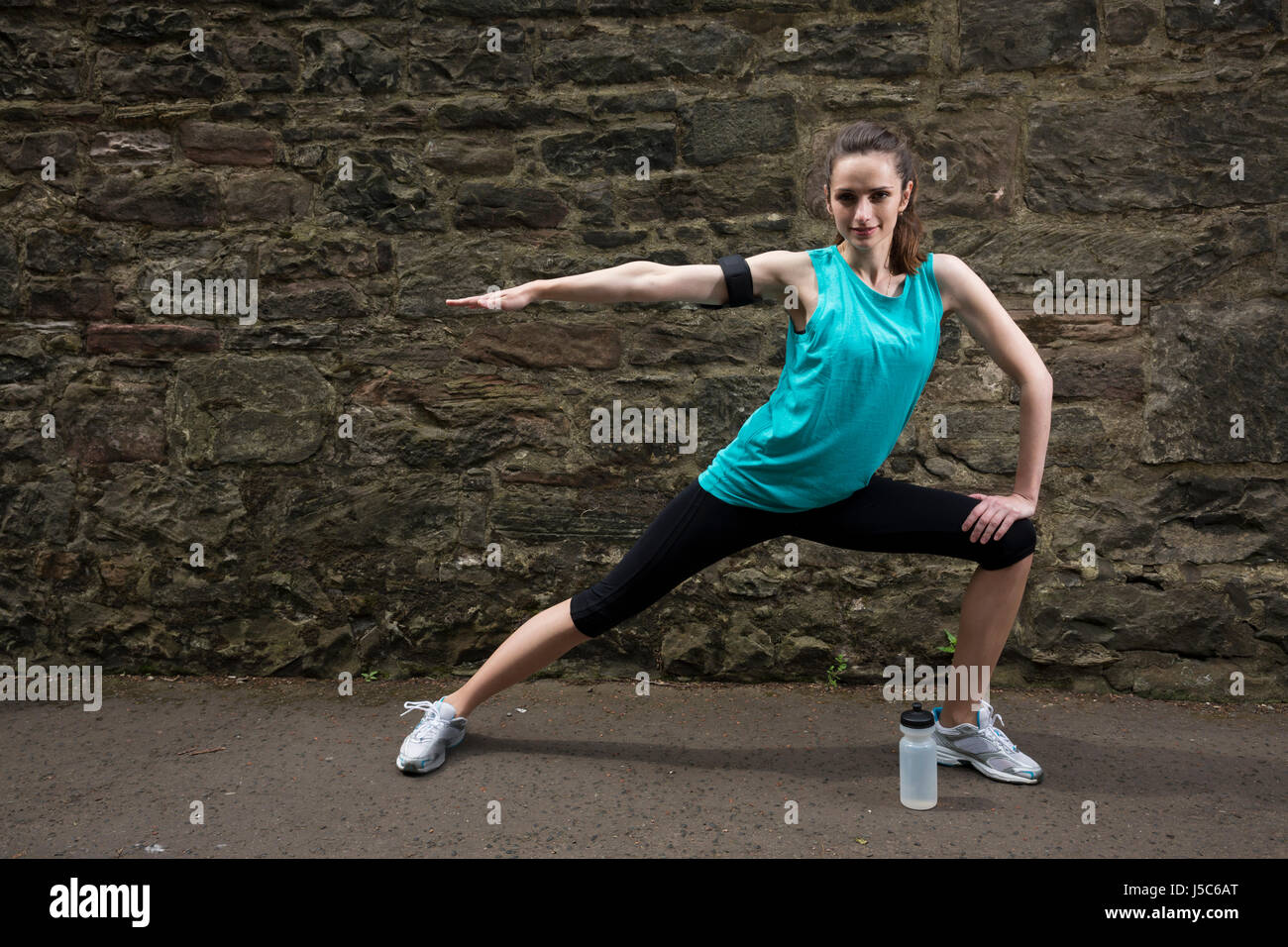 Athletic donna stretching prima o dopo la formazione. Azione e uno stile di vita sano concetto. Foto Stock