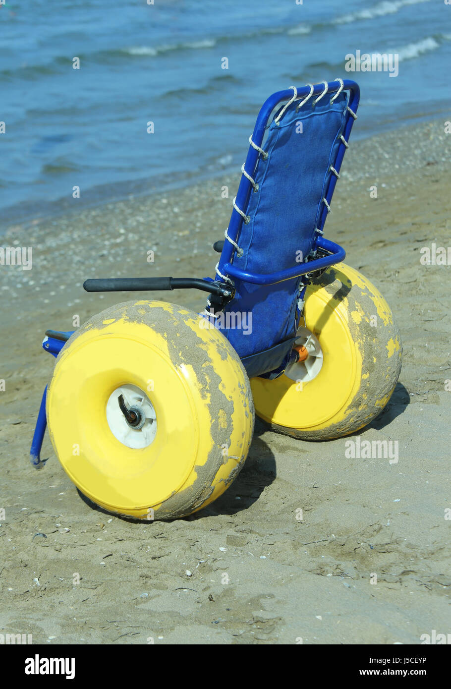 Sedia a rotelle speciale con grande giallo ruote gonfiabili per portare le  persone disabili all'interno dell'acqua di mare Foto stock - Alamy