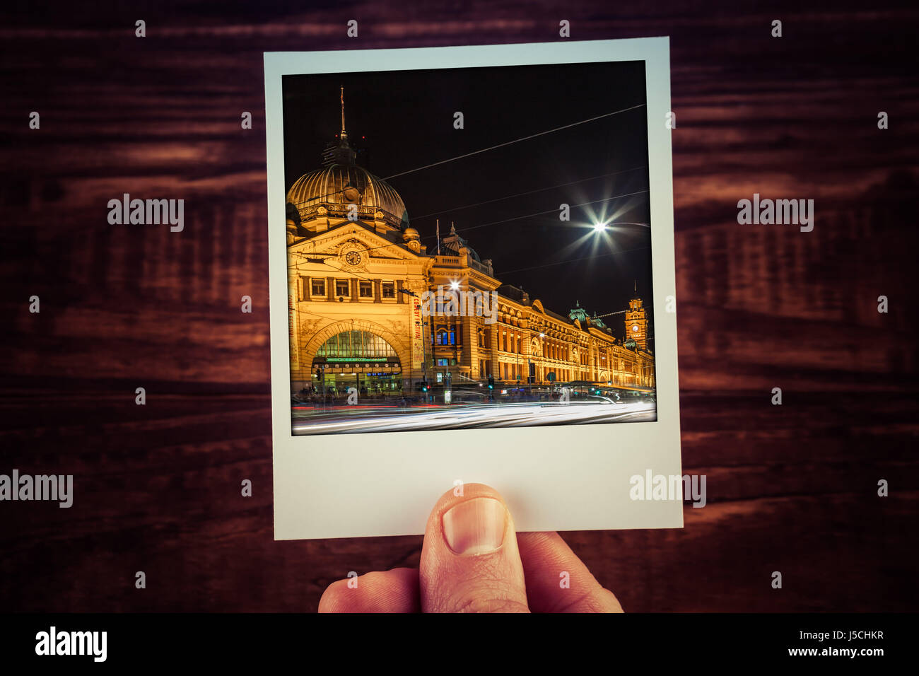 Mano azienda polaroid cartolina di Flinders Street Station di notte. Melbourne, Australia. I ricordi di viaggio scrapbooking di buoni tempi con spazio di copia Foto Stock