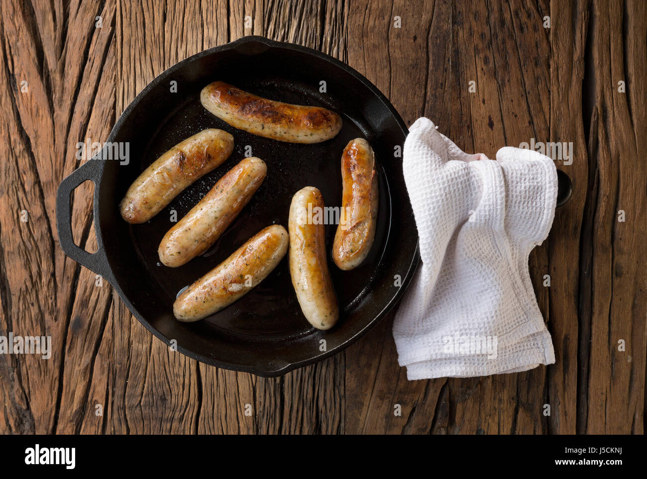 Macellerie Gourmet salsicce in padella su un rustico sfondo di legno. Foto Stock